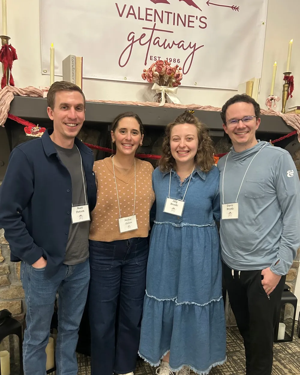 Two couples smiling in front of the Valentine's Getaway banner